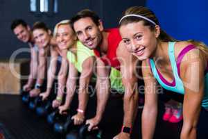 Smiling athletes exercising with kettlebells