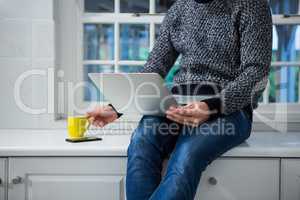 Man using laptop in the kitchen