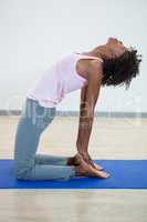 Woman performing yoga on exercise mat