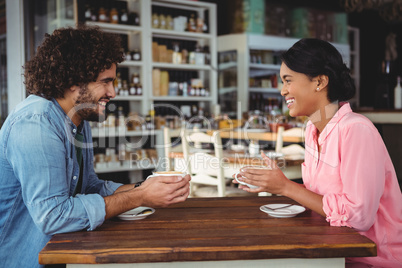 Couple smiling and holding coffee cup