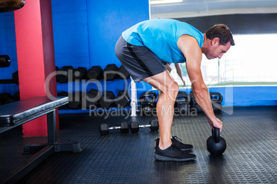 Side view of athlete with kettlebell in gym