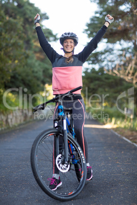 Female biker standing with mountain bike in country side
