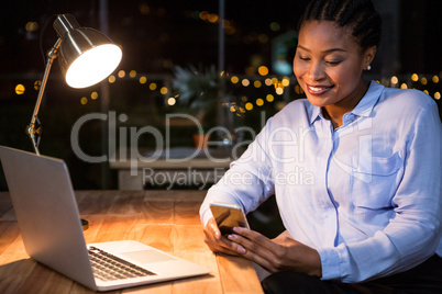 Businesswoman using mobile phone at her desk