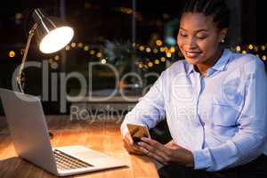 Businesswoman using mobile phone at her desk