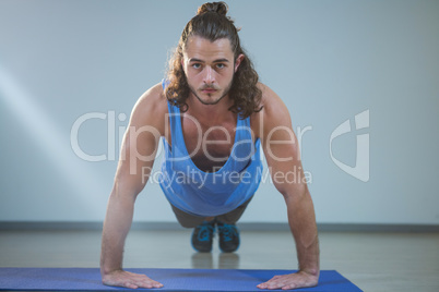 Man doing push-up on exercise mat