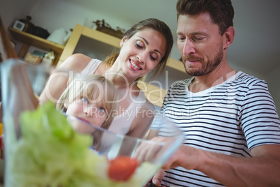Family preparing salad in the kitchen