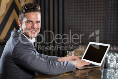 Man using laptop in bar counter