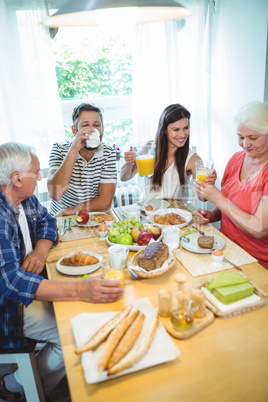 Happy couple having breakfast with their parents