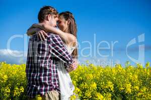 Romantic couple embracing each other in mustard field