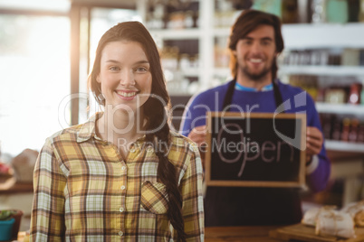 Waiter holding open signboard and standing with customer