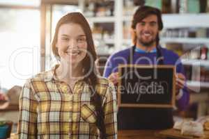 Waiter holding open signboard and standing with customer