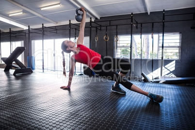 Sporty female athlete holding kettlebell in gym