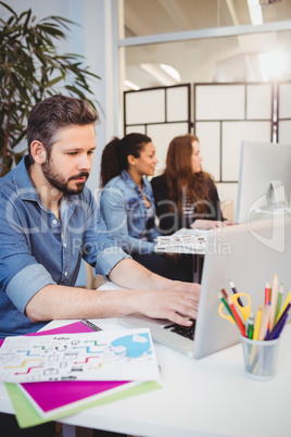 Creative business people using technologies at desk