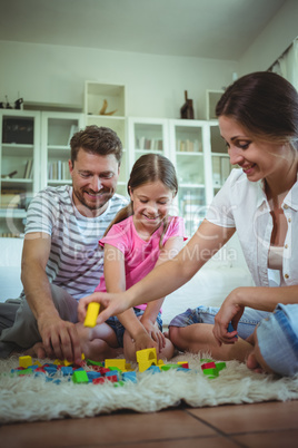 Parents and daughter playing with building blocks