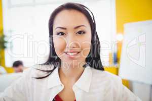 Portrait of beautiful executive with headphones at creative office