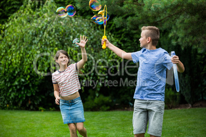 Kids playing with bubbles in the park