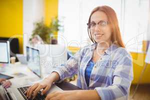 Portrait of smiling female graphic designer working with laptop