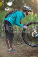 Female biker repairing mountain bike