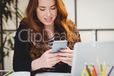Happy woman using cellphone at creative office