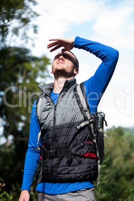 Male hiker shielding his eyes