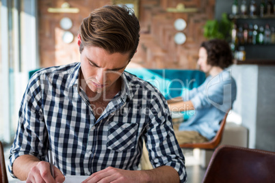 Man writing in coffee shop