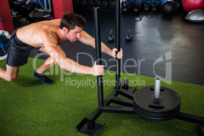 Shirtless man exercising in gym