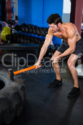 Athlete exercising with sledgehammer swing