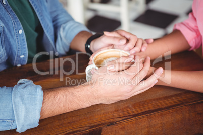 Mid-section of couple holding hands