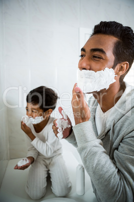 Father and son applying foam on face together