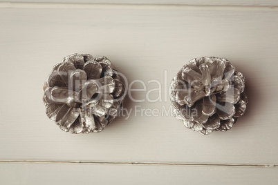 Two pine cones on wooden table