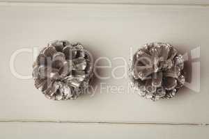 Two pine cones on wooden table