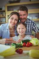 Portrait of happy family leaning on kitchen worktop