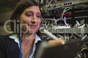 Technician maintaining record of rack mounted server on clipboard