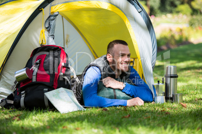 Smiling hiker lying in tent
