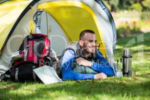 Smiling hiker lying in tent
