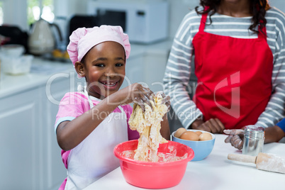 Girl preparing cake with mother