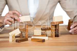 Businesswoman placing wooden block on a tower
