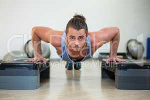 Portrait of man doing aerobic exercise on stepper