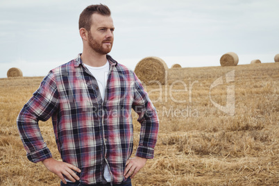 Farmer standing with hands on hips in the field