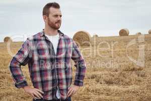 Farmer standing with hands on hips in the field