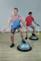 Men exercising on bosuball