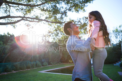 Father holding daughter in arms