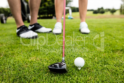 Male instructor assisting woman in learning golf