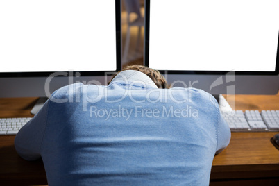 Businessman sleeping on desk while working in office