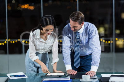 Businessman discussing with colleague over digital tablet