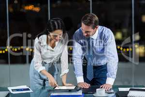 Businessman discussing with colleague over digital tablet