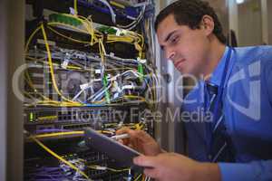 Technician maintaining record of rack mounted server on clipboard