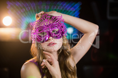 Woman posing with masquerade in bar