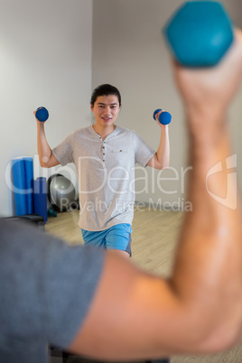 Man doing step aerobic exercise with dumbbell on stepper