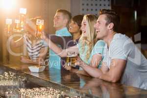 Group of friends holding glass of beer in party